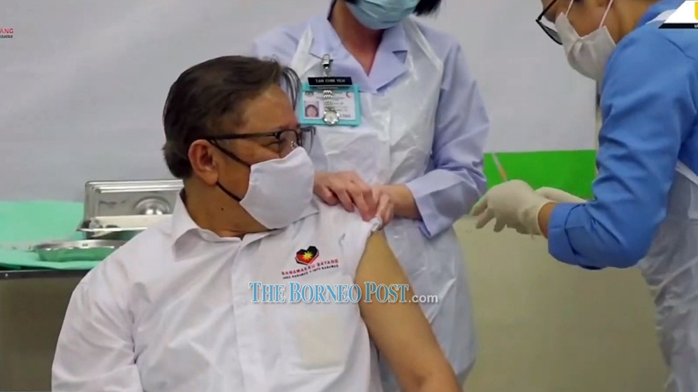 Medical personnel prepare to administer the vaccine to Abang Johari at the live telecast event. u00e2u20acu201d Borneo Post picnn