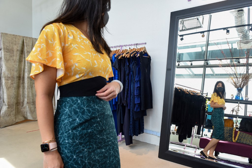 This picture taken on January 29, 2021 shows Sue-Anne Chng trying on secondhand clothes at The Fashion Pulpit store in Singapore. u00e2u20acu201d AFP pic