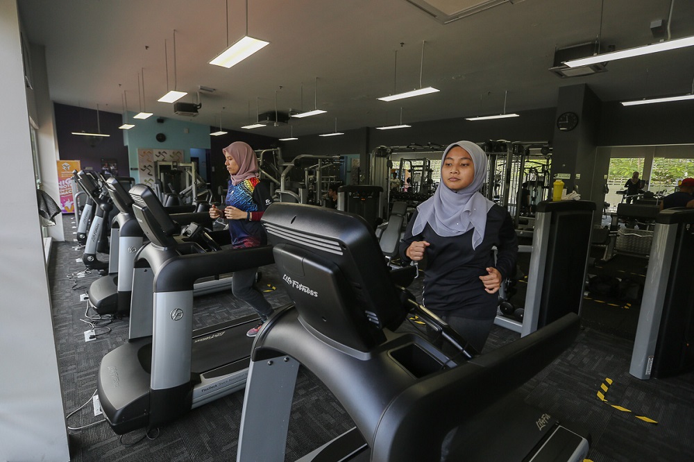 Dr Izzah Amirah Mohd Ahir (right) and Dr Shahdattul Mawarni Indahwan Shahputri Taib runs on a treadmill at Anytime Fitness in Shah Alam February 12, 2021. u00e2u20acu2022 Picture by Yusof Mat Isa