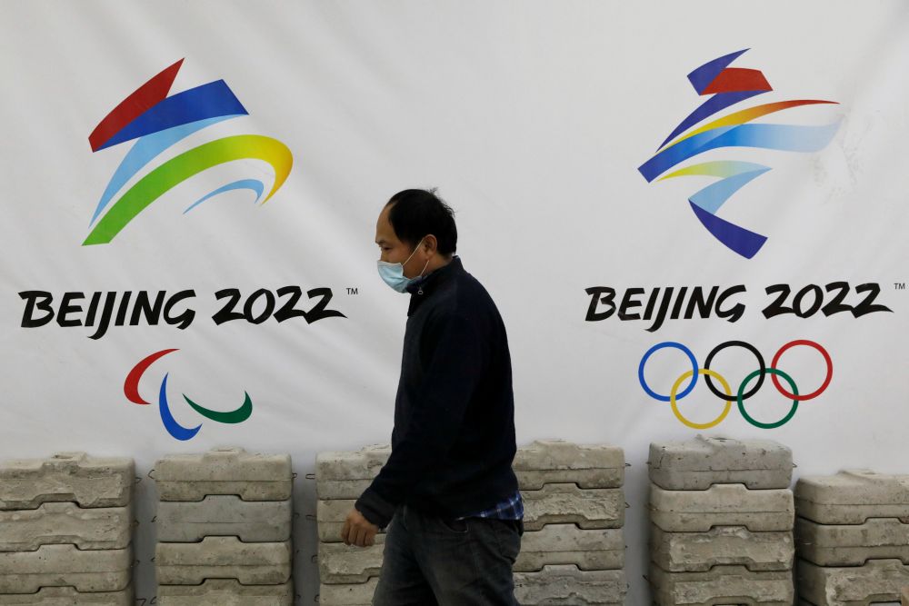 A man walks past a board with logos of 2022 Winter Olympic Games, at a souvenir shop under renovation in Beijing January 29, 2021. u00e2u20acu201d Reuters picnn