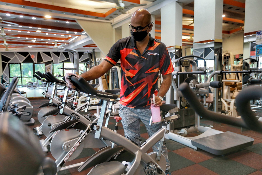 Enrich Fitness gym owner Krishna Kumar sanitises his gym equipments to comply with NSC SOPs February 12, 2021. — Picture by Ahmad Zamzahuri