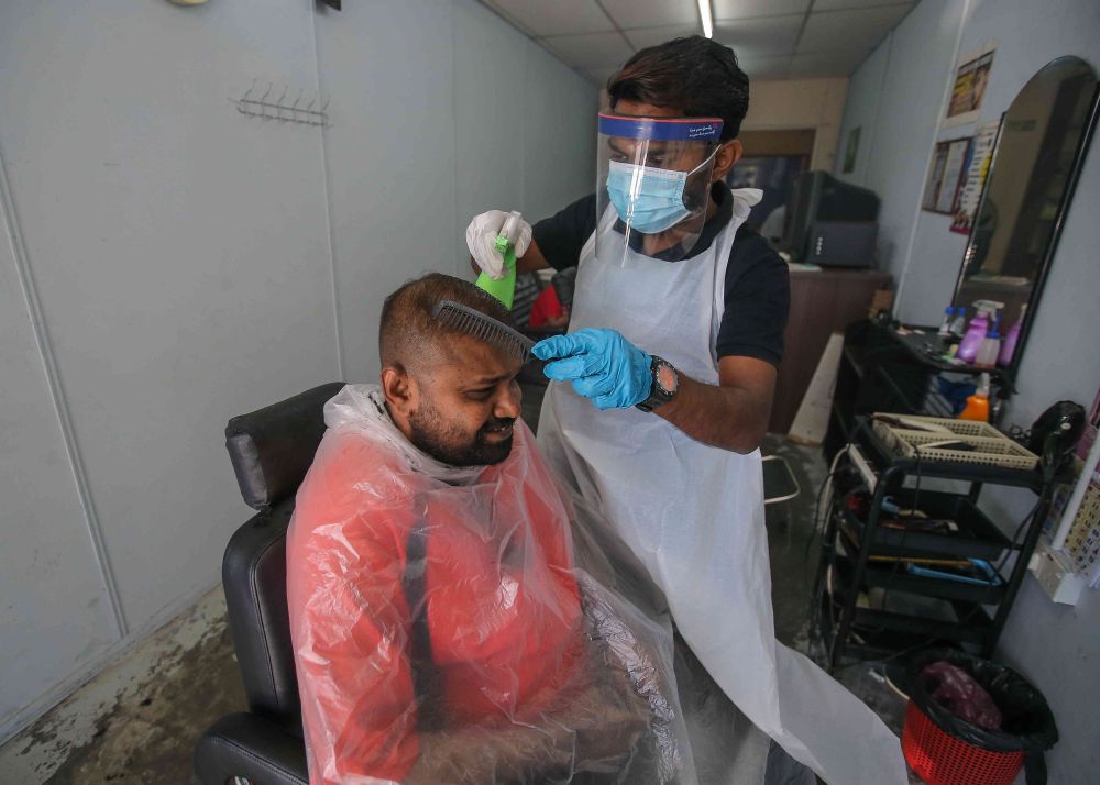 Barber Logasvaran Konasegaran gives his customer a haircut at his shop in Taman Tinggi, Ipoh February 5, 2021.  u00e2u20acu201d Picture by Farhan Najib