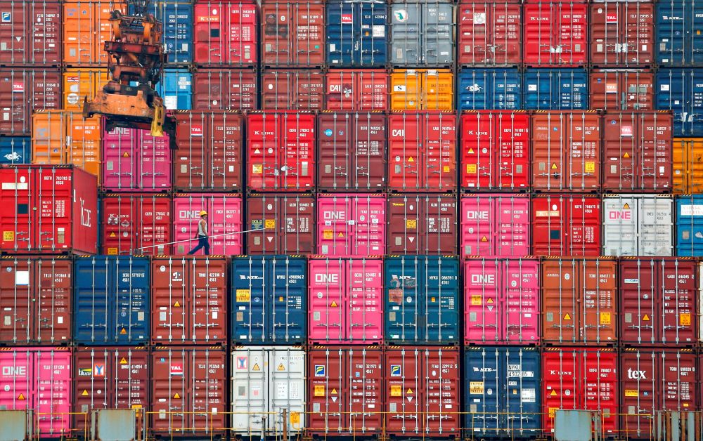A worker walks on stacks of containers at the Tanjung Priok port in Jakarta January 22, 2021.. u00e2u20acu201d Reuters pic