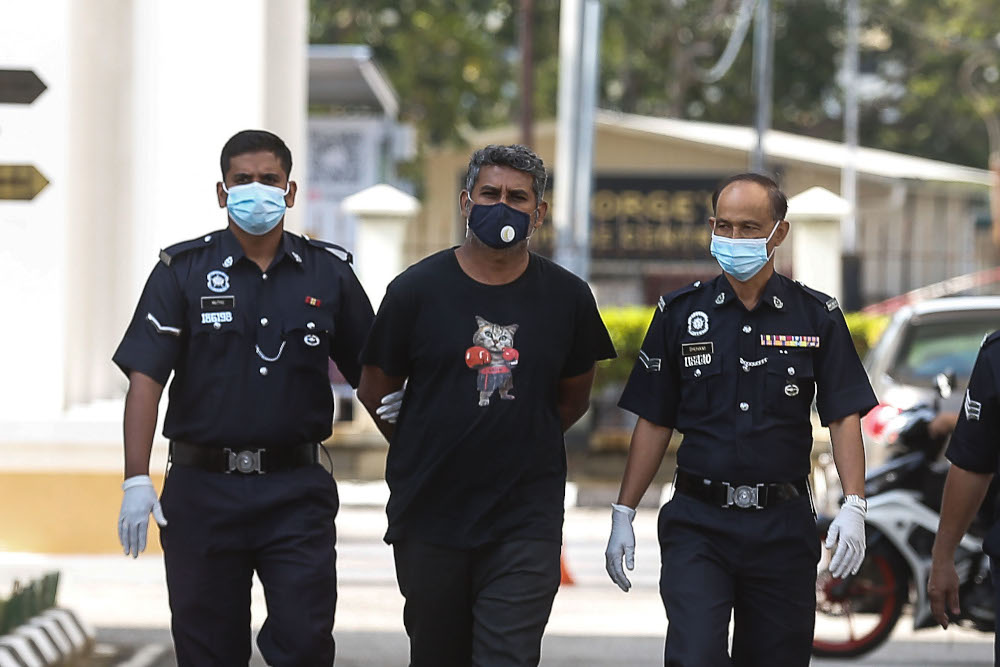 K. Haridas, 40 escorted by the police to face his charge at Penang Criminal Session Court February 9, 2021. u00e2u20acu201d Picture by Sayuti Zainudin