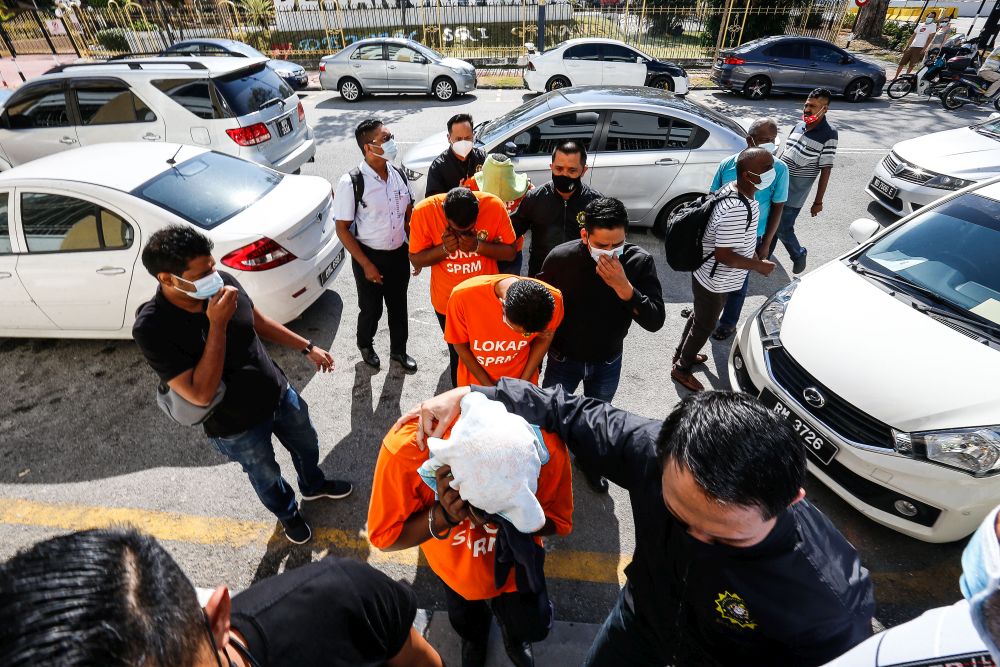 MACC personnel escort four detainees to be remanded at the George Town Magistrateu00e2u20acu2122s Court February 26, 2021. u00e2u20acu201d Picture by Sayuti Zainudin
