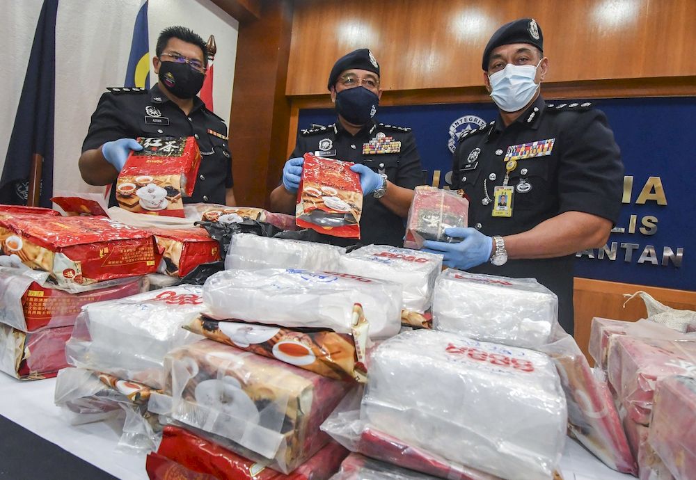 Kelantan police chief Datuk Shafien Mamat (centre) with his officers showing a total of 101 kilograms (kg) of syabu drugs worth RM3.6 million seized in a raid in Kampung Lubuk Gong Pasir Mas, Feb 25, 2021. u00e2u20acu201d Bernama pic