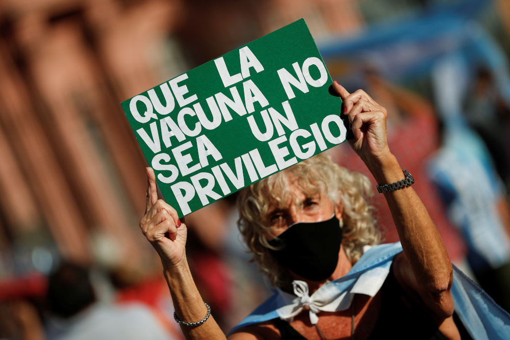 A demonstrator holds a placard reading u00e2u20acu02dcDonu00e2u20acu2122t make the vaccine a privilegeu00e2u20acu2122 during a protest against the government over a u00e2u20acu02dcVIPu00e2u20acu2122 vaccine scandal outside the Casa Rosada Presidential Palace, in Buenos Aires February 27, 2021. u00e2u20acu201d Reuters pic
