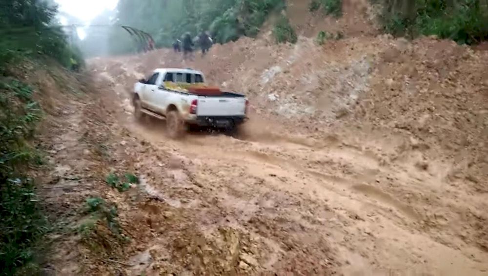 The muddy road to Sungai Magandai is a hindrance in sending working papers to her students.