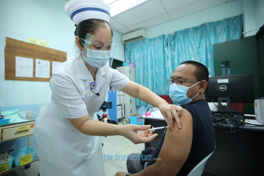 Utusan Borneo journalist Saibi Gi is seen receiving the Covid-19 vaccine jab in Kota Samarahan February 26, 2021. u00e2u20acu201d Picture by Borneo Post