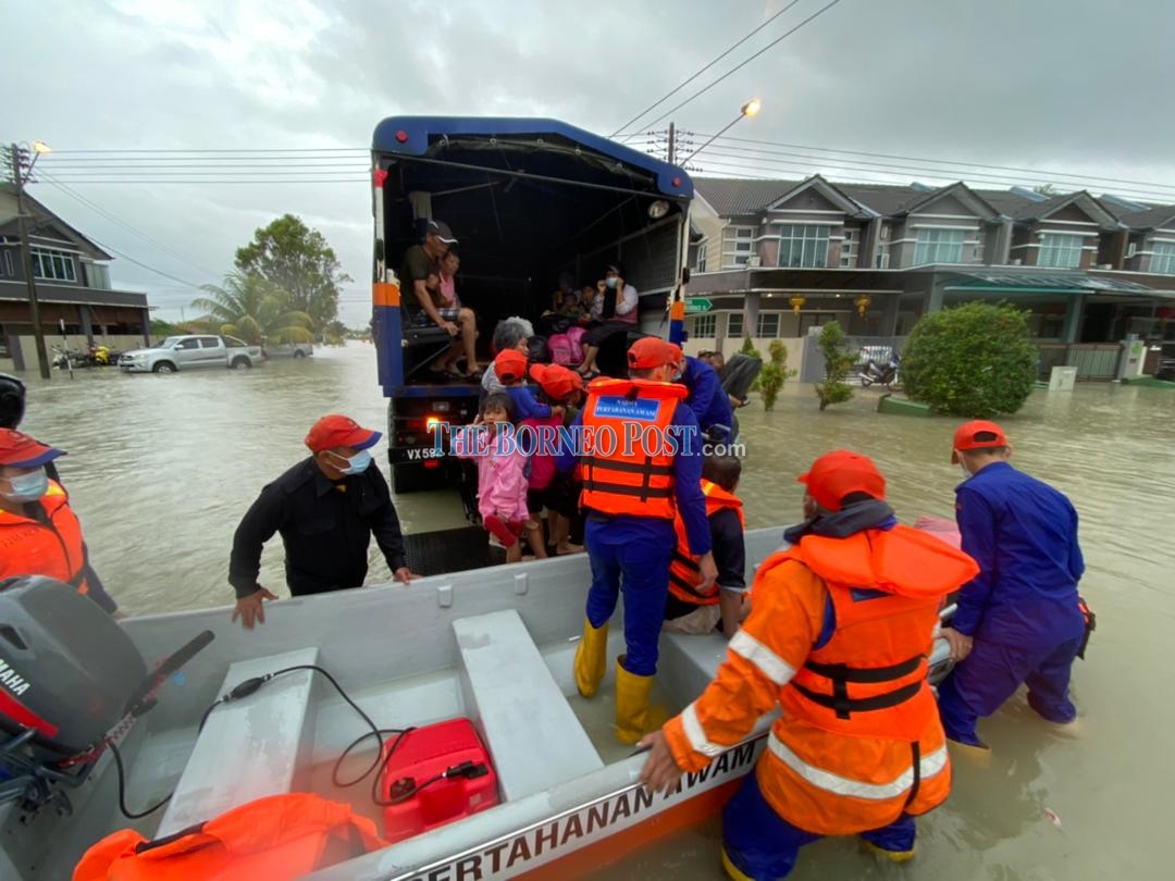 Members from the Civil Defence Force assisting residents from Kampung Sinar Budi, Batu Kawa to evacuate the area. u00e2u20acu2022 Borneo Post pic