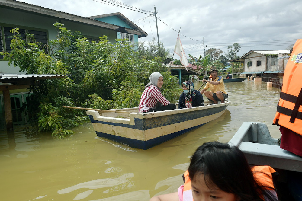 Villagers in Kampung Hulu Serian navigate through floodwater in Serian, Sarawak, February 5, 2021. u00e2u20acu201d Bernama pic