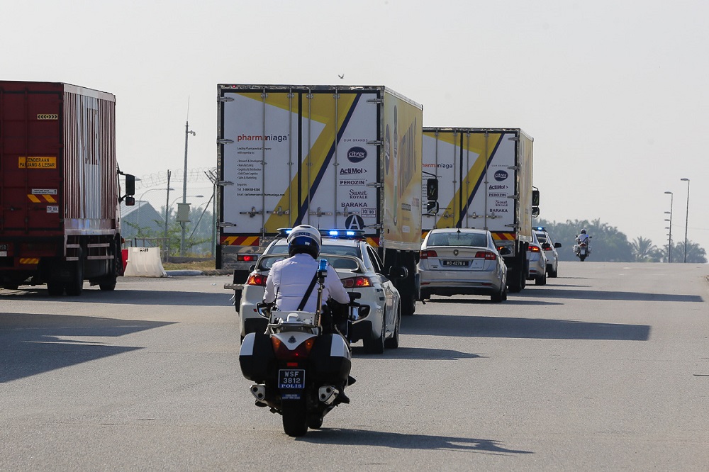 A convoy of vehicles carry the Sinovac Covid-19 vaccine with police escort from Cargo Village in KLIA February 27, 2021. 
