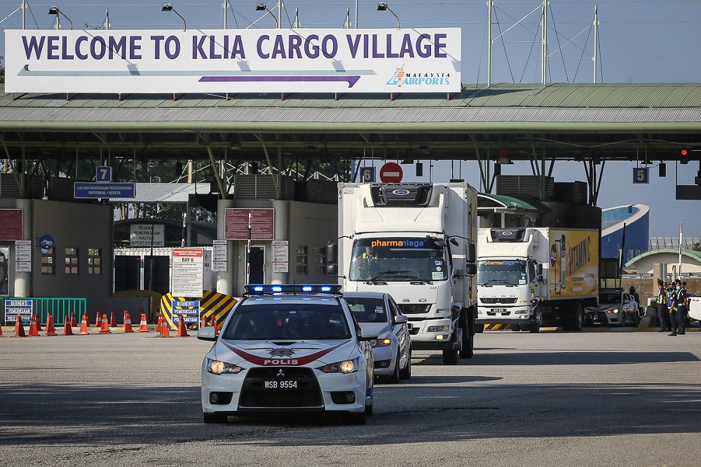 A convoy of vehicles carry the Sinovac Covid-19 vaccine with police escort from Cargo Village in KLIA February 27, 2021. u00e2u20acu2022 Picture by Yusof Mat Isa
