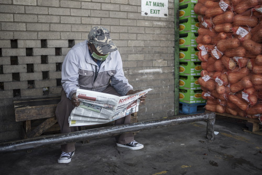 A man reads a newspaper next to a pallet of butternuts at the City Deep Fresh Product Market in Johannesburg, February 15, 2021. u00e2u20acu201d AFP pic