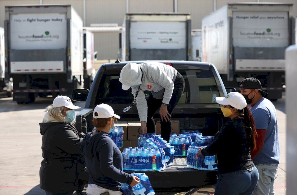 Volunteers load cases of water and emergency food boxes into a truck at the Houston Food Bank on February 20, 2021 in Houston, Texas. u00e2u20acu201d AFP pic