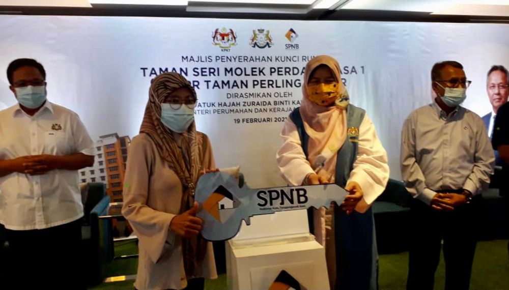 Datuk Zuraida Kamaruddin hands over a replica key to a recipient during the Taman Seri Molek Persana Phase 1 and PPR Taman Perling housing ceremony in Johor Baru February 19, 2021. u00e2u20acu201d Picture by Ben Tan