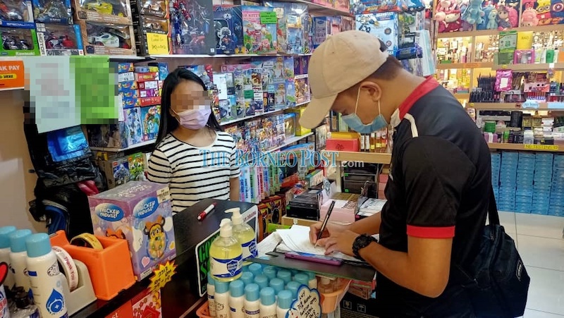 A member of the inspection team member taking down details of a business premises during the operation. u00e2u20acu201d Borneo Post Online