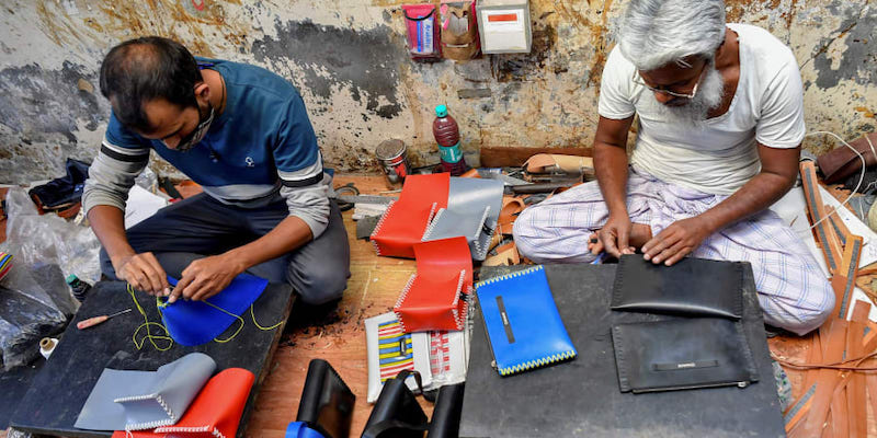 Artisans Rahul Dattatrey Gorey (left) and Kalamudeen Ansari stitch new recycled rubber bags for 'Chamar Studio' by designer Sudheer Rajbhar. u00e2u20acu201d AFP pic