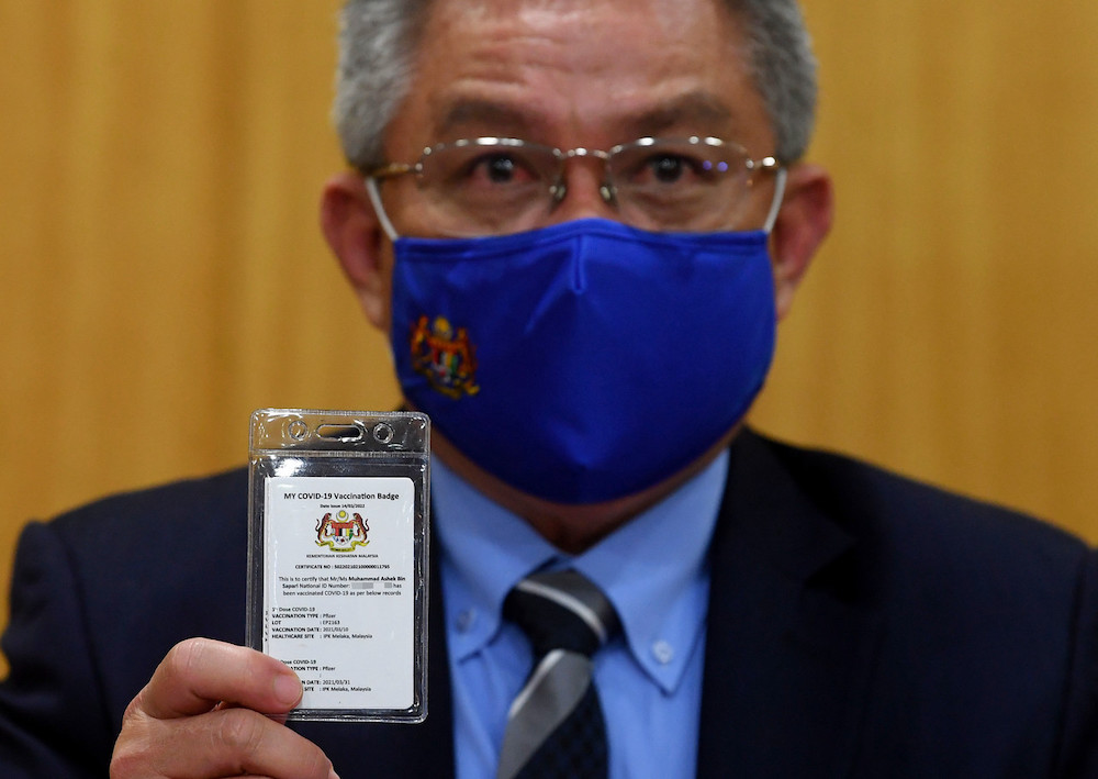 Health Minister Datuk Seri Dr Adham Baba showing the My Covid-19 Vaccination badge during a press conference at the Health Ministry, March 17, 2021. u00e2u20acu201d Bernama pic