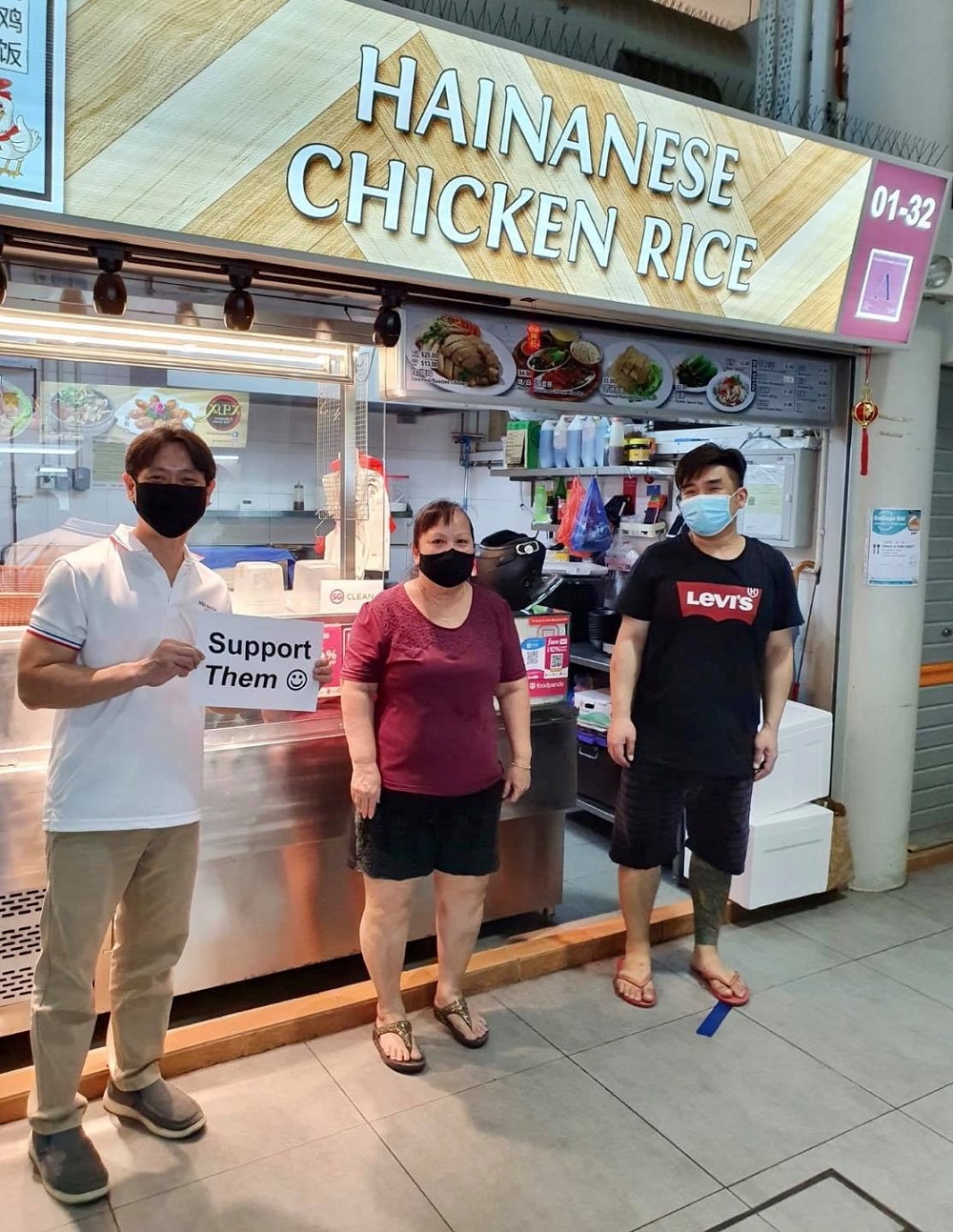 Singapore Member of Parliament Louis Ng holds a placard calling for support for local food businesses during a visit to Yishun Park Hawker Centre in Singapore, in this photo posted on Facebook June 20, 2020. u00e2u20acu201d Picture from Facebook/Louis Ng via Reuters