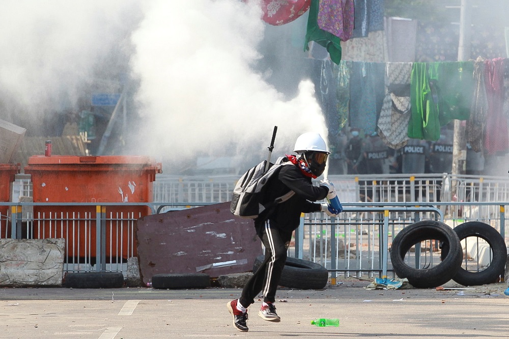 An anti-coup demonstrator sprays a fire extinguisher as he runs away from a barricade during a protests in Yangon March 9, 2021. u00e2u20acu201d Reuters pic