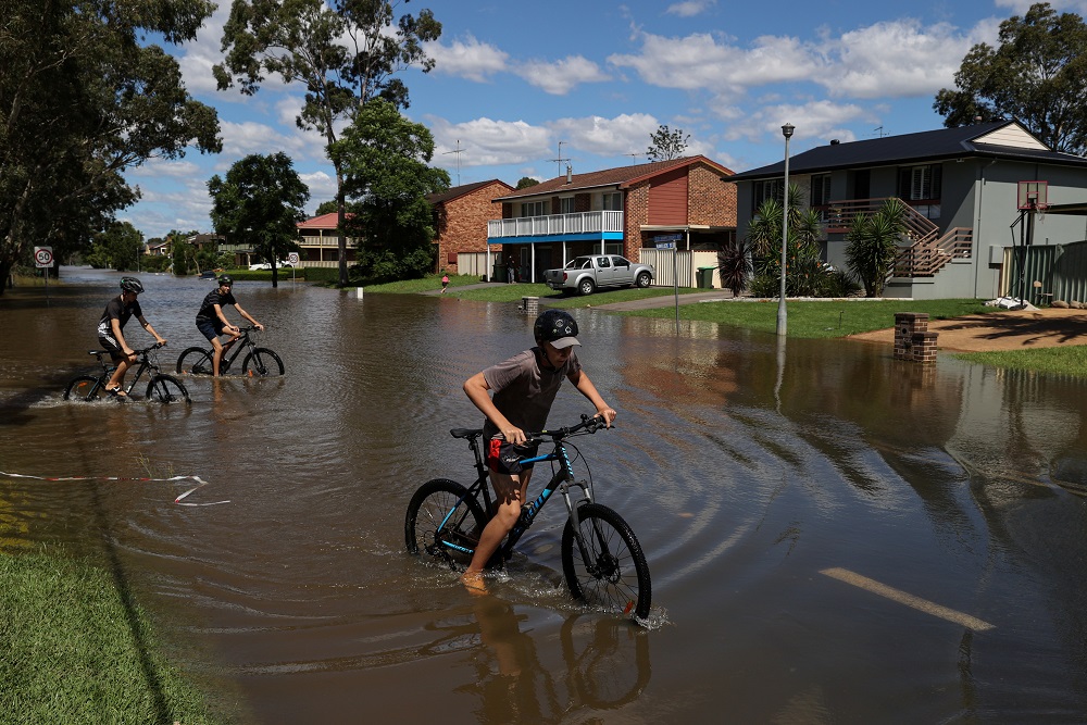 Kids ride bicycles through floodwaters as severe flooding affects the suburb of McGraths Hill after days of heavy rain in the state of New South Wales, in Sydney March 24, 2021. u00e2u20acu201d Reuters pic