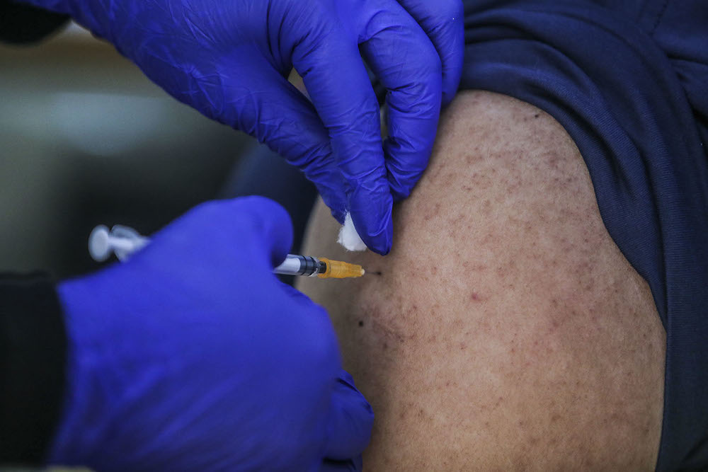 A healthcare worker administers a dose of the Pfizer-BioNTech Covid-19 vaccine to a frontliner at the UiTM Private Specialist Centre in Sungai Buloh March 2, 2021. u00e2u20acu2022 Picture by Hari Anggara