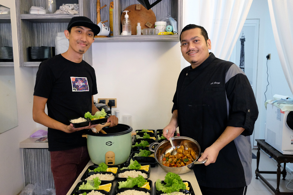 Fandi Khor (left) and Nisha Rezqi (right) took the opportunity to start a business selling packed lunches during MCO. u00e2u20acu201d Picture by Steven Ooi KE