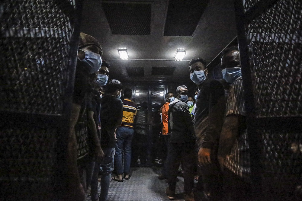 Foreigners nabbed during a raid are seen in an Immigration Department vehicle, in Kuala Lumpur March 6, 2021. 