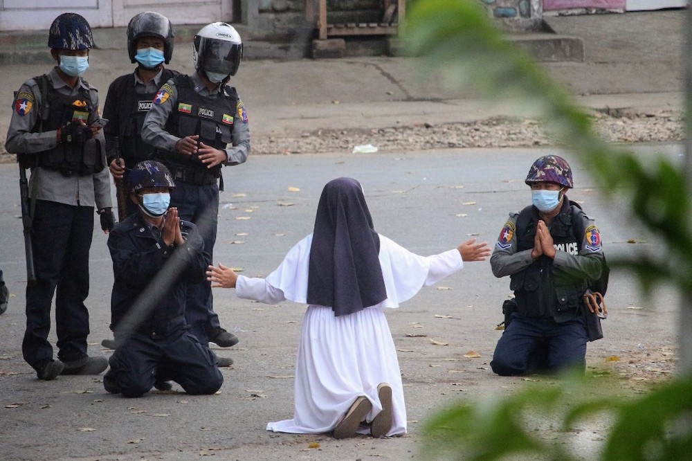 This handout photo taken on March 8, 2021 and released on March 9 by the Myitkyina News Journal shows a nun pleading with police not to harm protesters in Myitkyina in Myanmar's Kachin state. u00e2u20acu201dMyitkyina News Journal handout via AFPn n