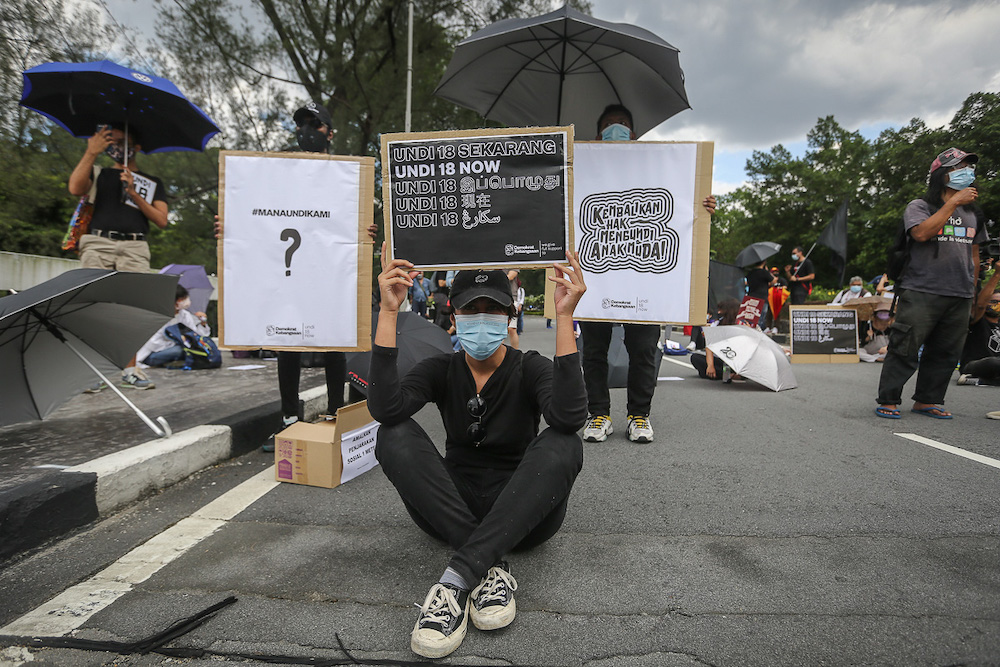 Protesters hold placards in front of Parliament building to protest the Election Commission's (EC) delay in allowing 18-years old to vote in Kuala Lumpur March 27, 2021. —Picture by Yusof Mat Isa