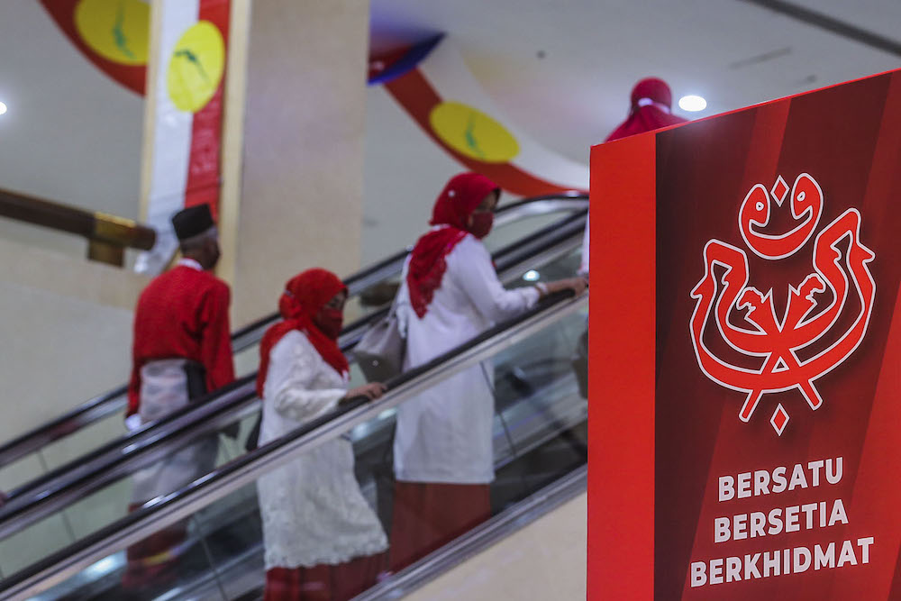 Umno members arrive for the party's 2020 general assembly in Kuala Lumpur March 28, 2021. ― Picture by Hari Anggara.
