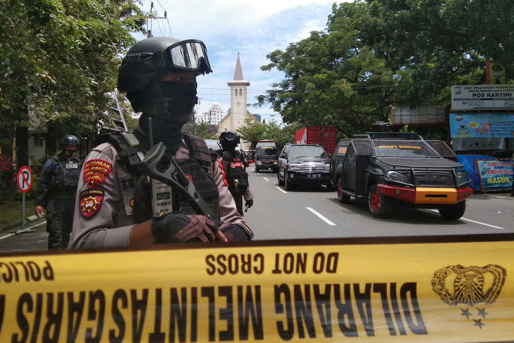 Armed police officers stand guard along a closed road following an explosion outside a Catholic church in Makassar, South Sulawesi province, Indonesia March 28, 2021 in this photo taken by Antara Foto. u00e2u20acu201d Antara Foto/Arnas Padda via Reuters