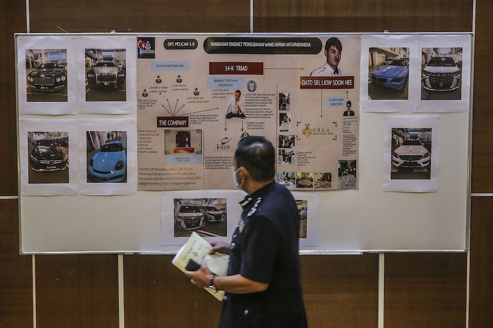 Inspector-General of Police Tan Sri Abdul Hamid Bador walks past a board with a mugshot of a suspect during a press conference at Bukit Aman March 30, 2021. ― Picture by Hari Anggara