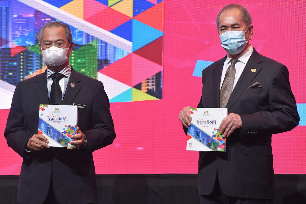 Prime Minister Tan Sri Muhyiddin Yassin and Minister for Entrepreneur Development and Cooperatives Datuk Seri Wan Junaidi Tuanku Jaafar with the Malaysian Cooperative Transformation Plan 2021-2025 (TransKoM) book that was launched today. u00e2u20acu201d Bernama pic