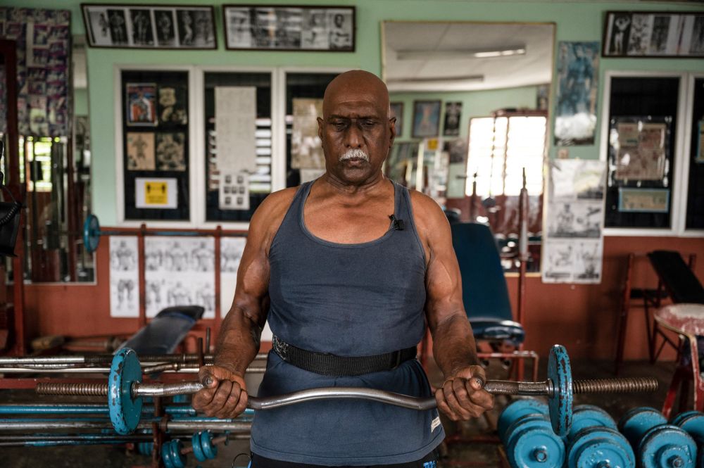 Bodybuilder A. Arokiasamy lifting a barbell at his gymnasium in Teluk Intan, Perak March 18, 2021. u00e2u20acu201d AFP pic