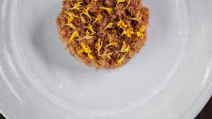 The cloud-like 'serabai' is made from Job's Tears and topped with a briny oyster emulsion, fish 'serunding' and marigold flowers – Picture courtesy of Dewakan's Facebook