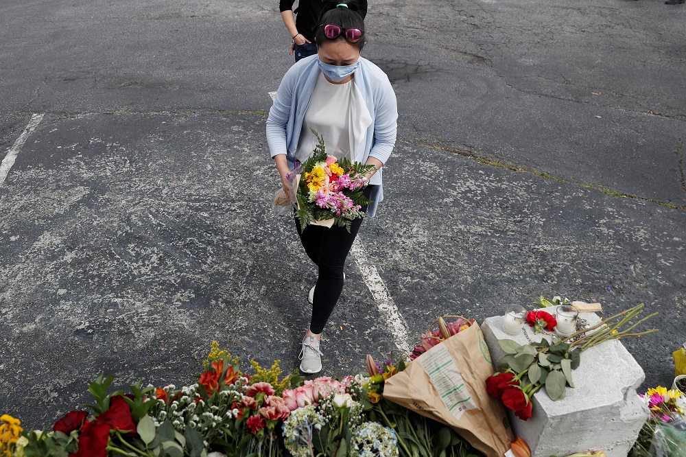 A woman lays flowers at a makeshift memorial outside the Gold Spa following the deadly shootings in Atlanta, Georgia March 19, 2021. u00e2u20acu2022 Reuters pic
