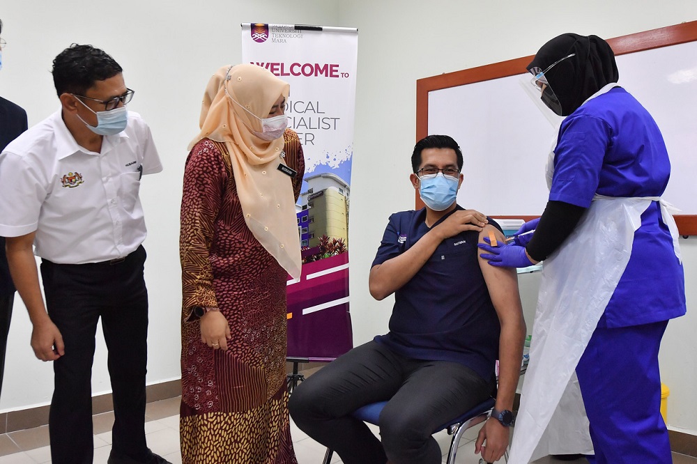 Minister of Higher Education Datuk Seri Noraini Ahmad (second, left) watches as a man receives the Covid-19 vaccination at the Sungai Buloh MARA University Hospital in Kuala Lumpur March 4, 2021. u00e2u20acu201d Bernama pic