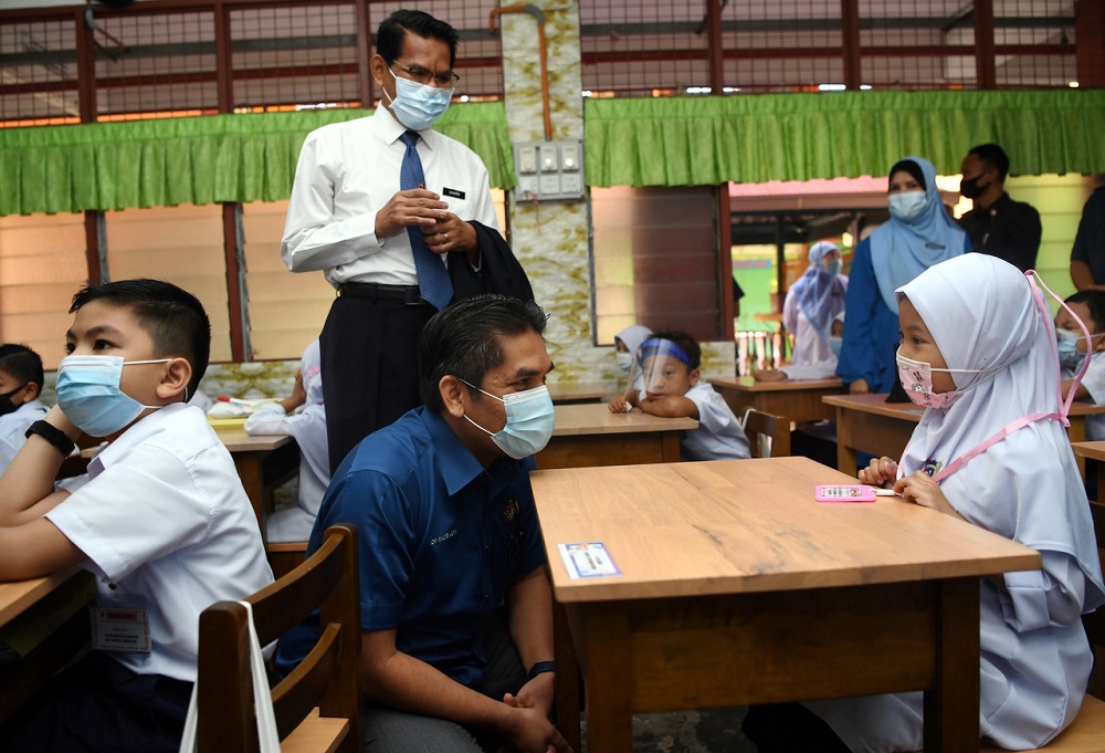 Senior Education Minister Datuk Radzi Jidin (centre) speaks to a student during his visit to Sekolah Kebangsaan King George V in Seremban March 8, 2021. u00e2u20acu201d Bernama pic