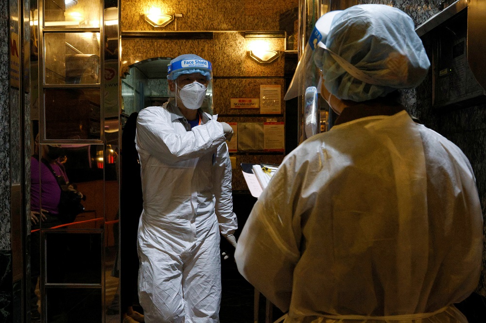 Workers wearing protective suits arrive at the locked-down part of the Sai Ying Pun area to contain a new outbreak of Covid-19 in Hong Kong March 15, 2021. u00e2u20acu2022 Reuters pic