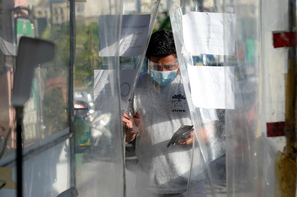A man wearing a face mask and a face shield as protection against Covid-19 enters a disinfection booth at a community quarantine checkpoint, in Pasay, Metro Manila, Philippines February 25, 2021. u00e2u20acu2022 Reuters pic