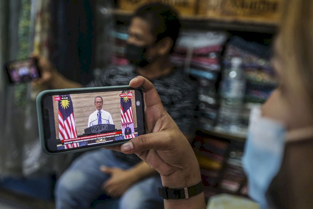 A store keeper at Jalan Tuanku Abdul Rahman watching the live telecast of Prime Minister Tan Sri Muhyiddin Yassin announcing the Pemerkasa programme, March 17, 2021. u00e2u20acu2022 Picture by Hari Anggara
