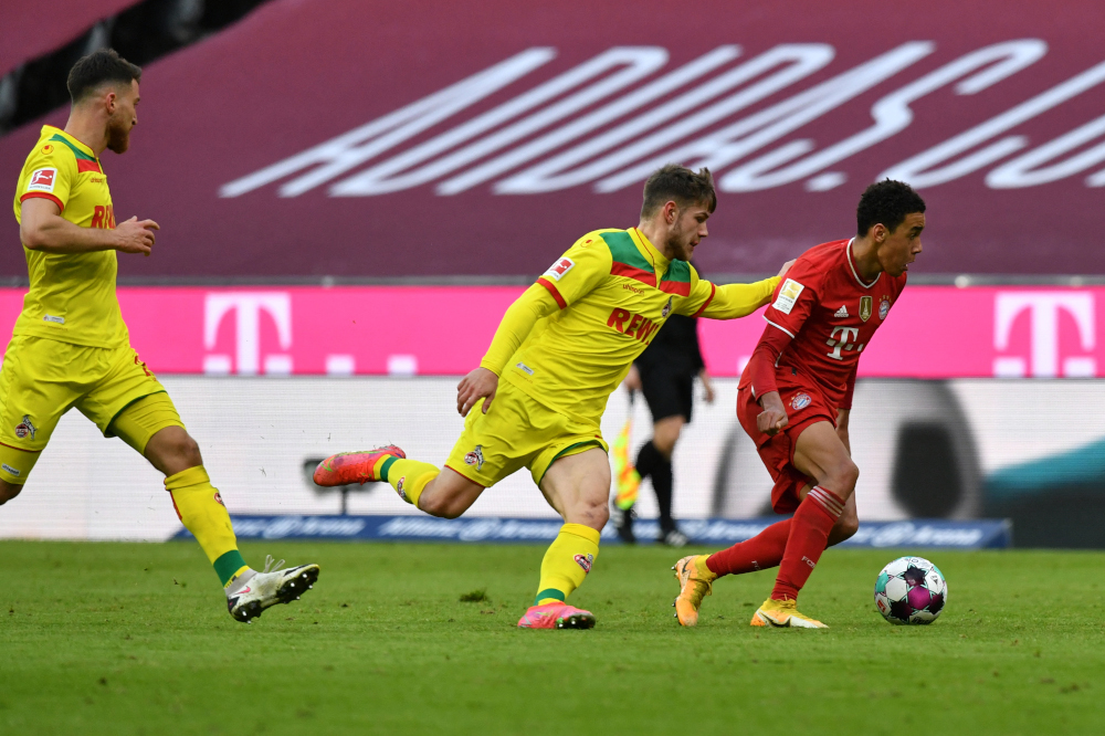 Cologne midfielder Jan Thielmann (centre) and Bayern Munich midfielder Jamal Musiala vie for the ball during the German first division Bundesliga football match FC Bayern Munich v FC Cologne in Munich, southern Germany February 27, 2021. u00e2u20acu201d AFP picnn