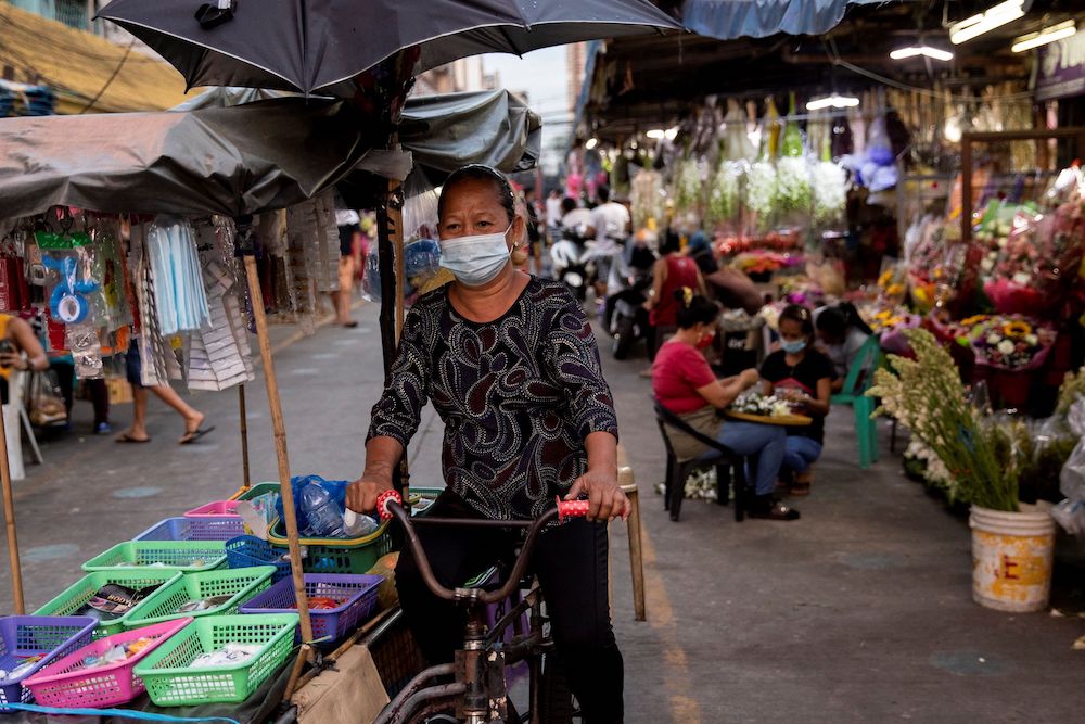 A vendor wearing a protective face mask, amid the spread of the coronavirus disease, cycles past a flower market in Manila, Philippines, March 12, 2021. u00e2u20acu201d Reuters pic