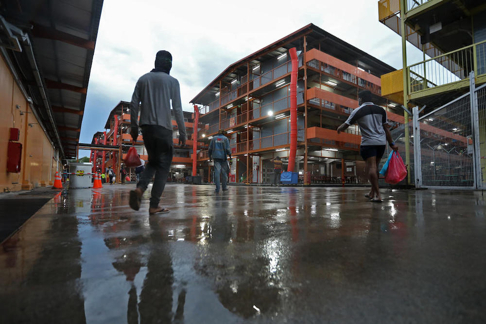 A year after the first dorm cluster was identified, many foreign workers have returned to work, but are still living with strict movement restrictions. u00e2u20acu201d Photo by Raj Nadarajan for TODAY