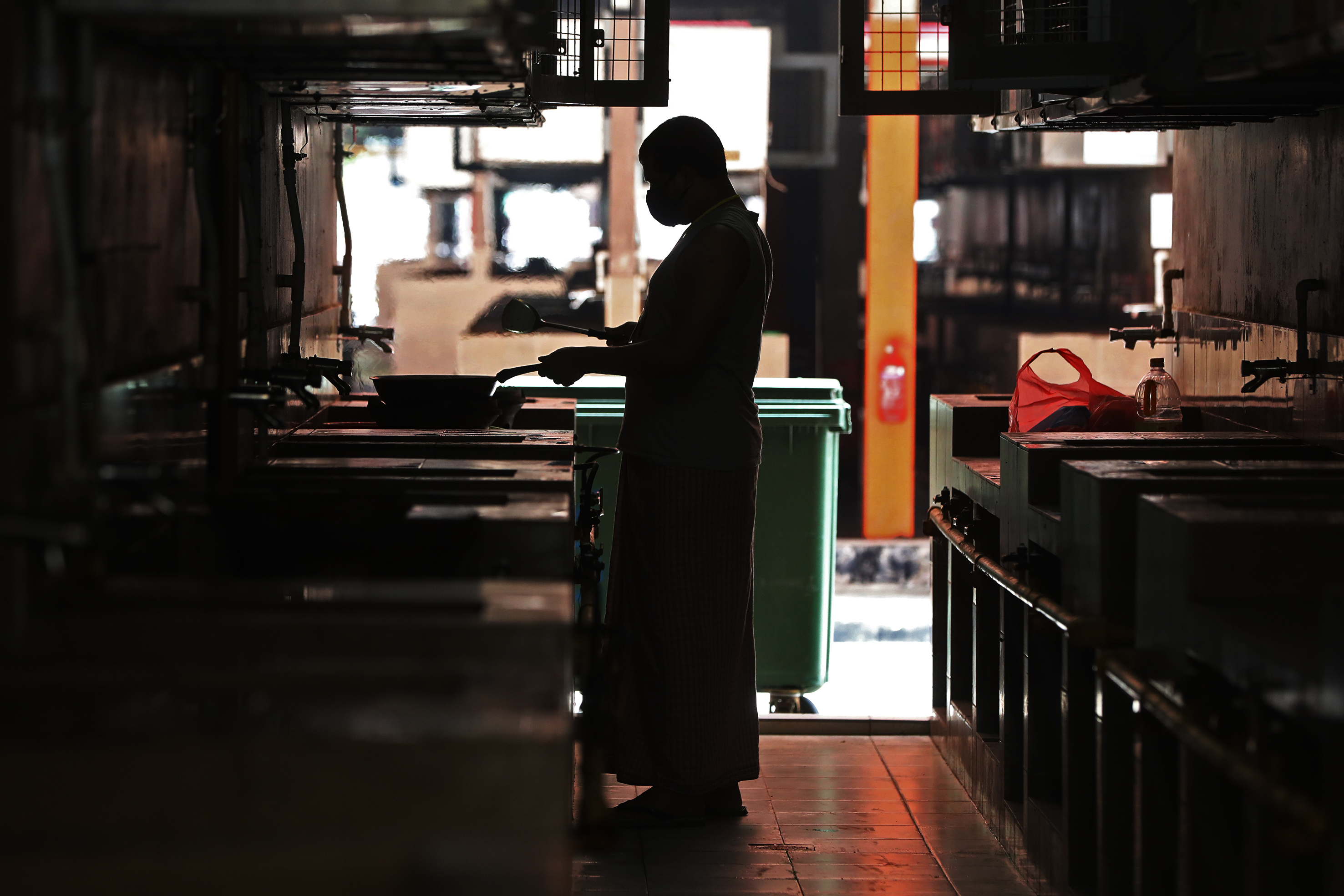 A resident at S11 @ Punggol cooking a meal at the communal kitchen. — Photo by Raj Nadarajan for TODAY