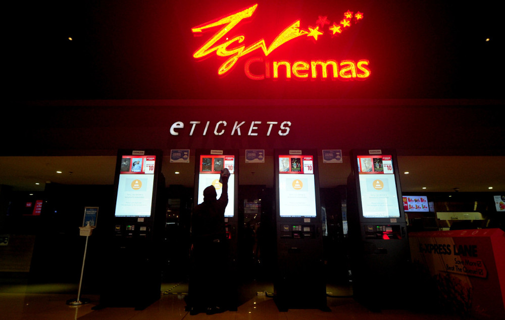 TGV Cinemas employee Maisura Mazhan, 29, cleaning the eTicket machine with disinfectant in preparation for the opening of the cinema at TGV Cinemas Bukit Tinggi Klang, March 4, 2021. u00e2u20acu201d Bernama pic n