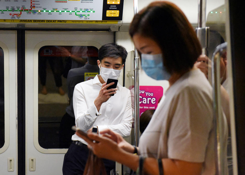 Commuters using their mobile phones on an MRT train in Singapore. u00e2u20acu2022 AFP pic via TODAY