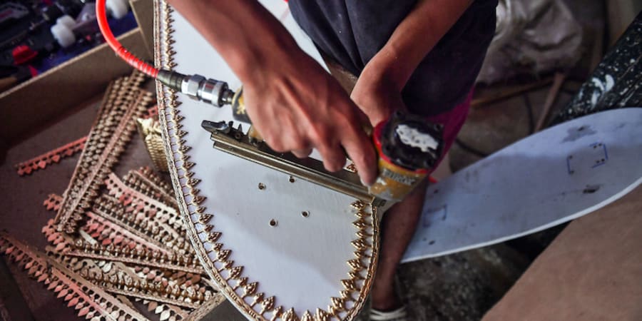 This photo taken on March 19, 2021 shows an employee from the Burapha coffin shop putting trimming on a skateboard. u00e2u20acu201d ETX Studio picnn